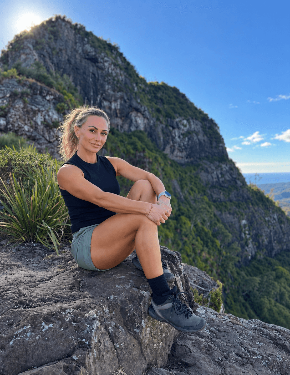 Penny sitting on a rock ledge above the ranges